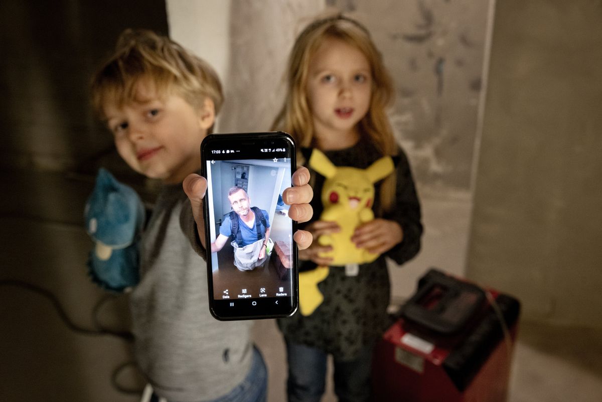 Vidar och Adele visar bilden på pappa Tomas som vadar genom vattnet i familjens villakällare i Gävle.