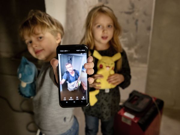 Vidar och Adele visar bilden på pappa Tomas som vadar genom vattnet i familjens villakällare i Gävle.