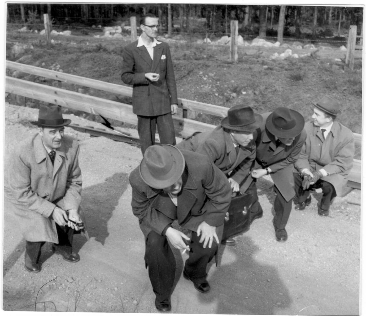 En grupp män går nedhukade längs en väg.