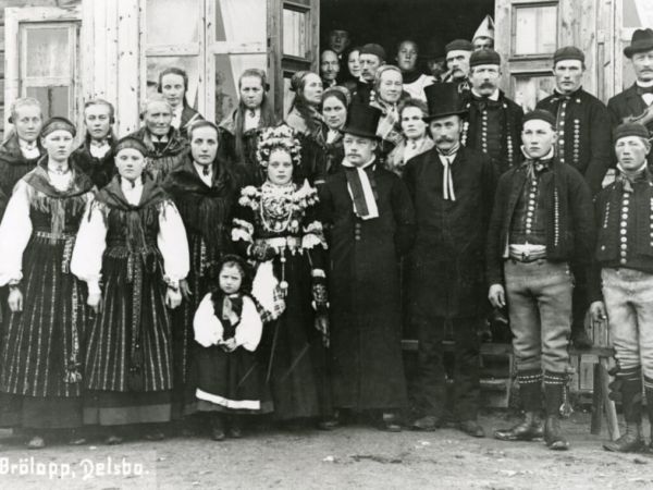 Ett bröllopsfoto med folkdräktsklädda personer.