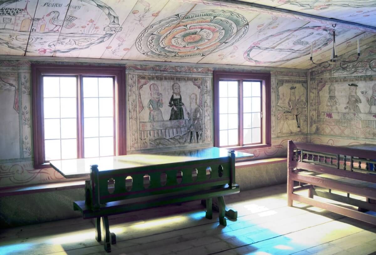 Interiör med väggmåleri och möbler i museets herrstuga.
