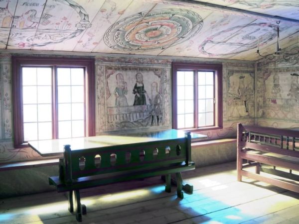 Interiör med väggmåleri och möbler i museets herrstuga.