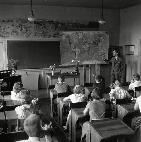 En skolklass undervisas av en magister i ett klassrum i Glösbo 1956.