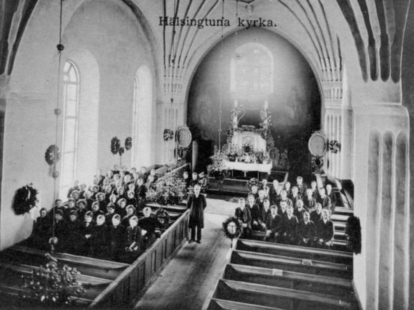 En kyrkointeriör med uppdelning av pojkar och flickor på olika sidor av mittgången.