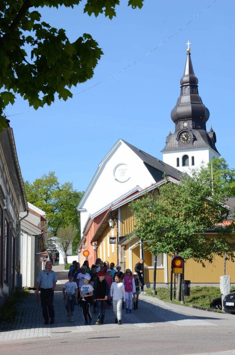Kyrkobyggnad med gata i förgrunden.