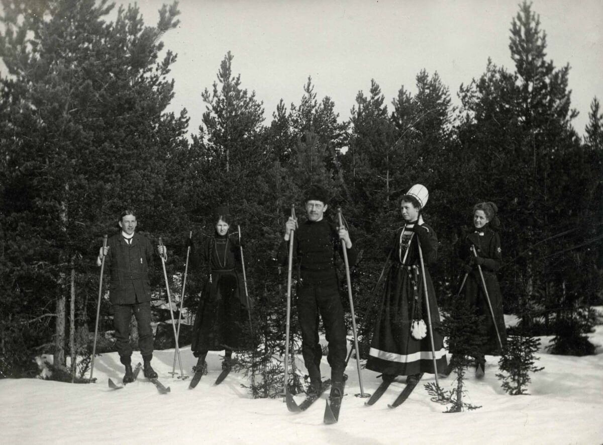 En skidgrupp står vid ett skogsbryn.