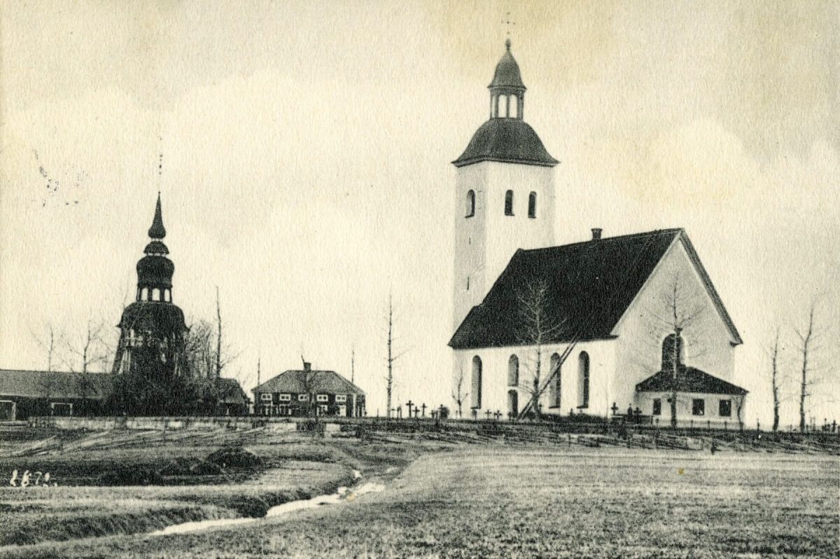 En kyrka, kyrkogård samt klocktorn.
