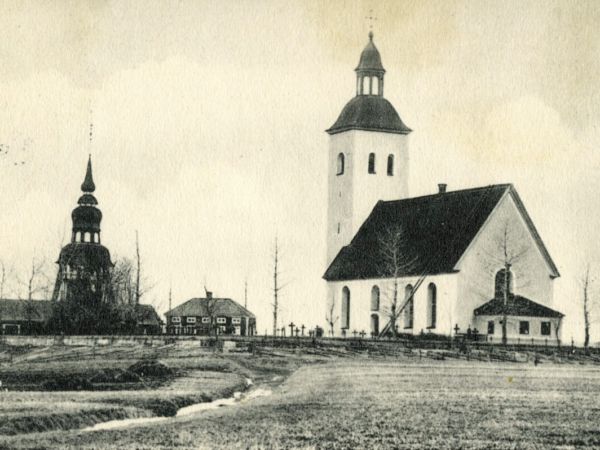 En kyrka, kyrkogård samt klocktorn.