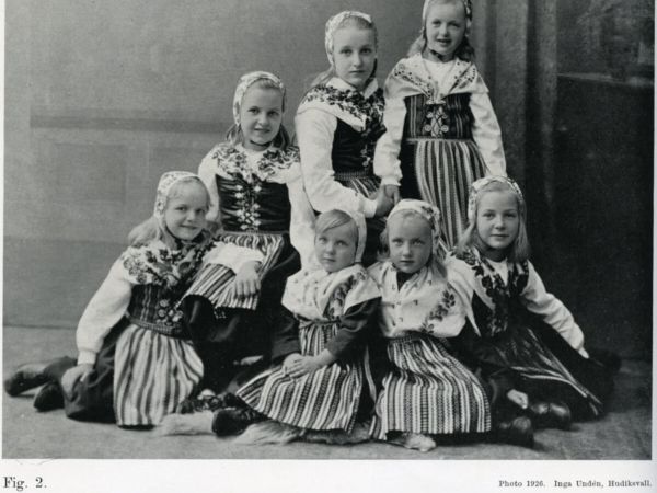 Sju flickor i folkdräkt.