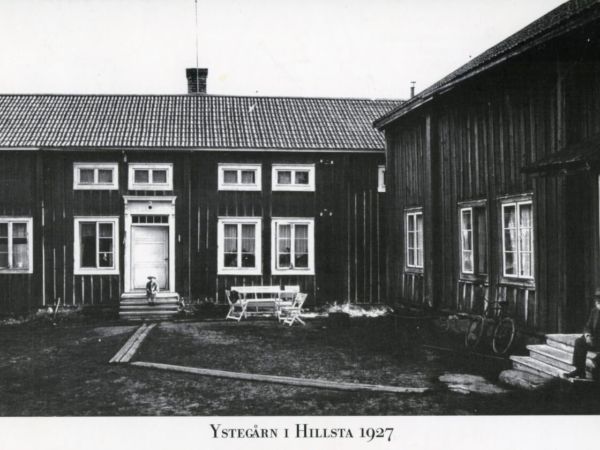 En pojke och en man sitter på varsin trappa vid Ystegården.
