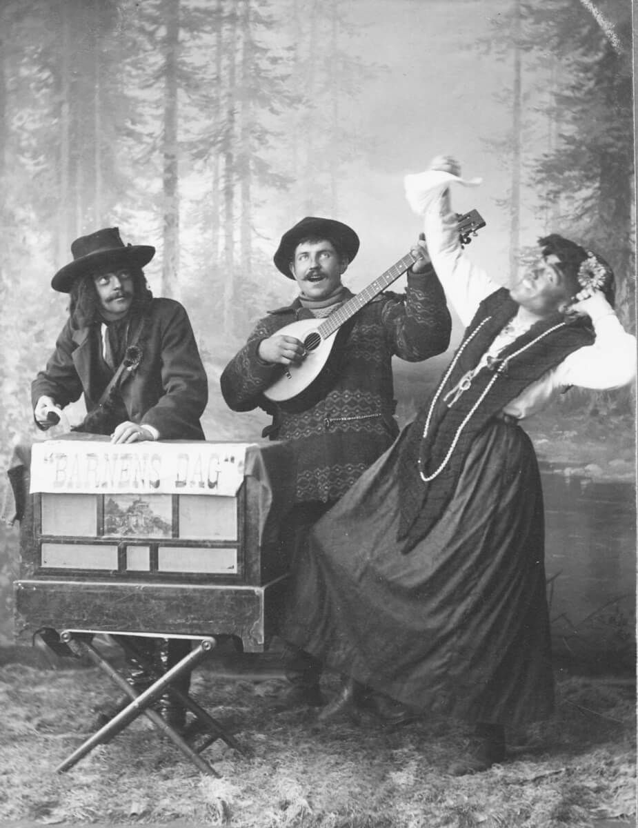 Ett musikuppträdande vid Barnens dag med tre utklädda personer.